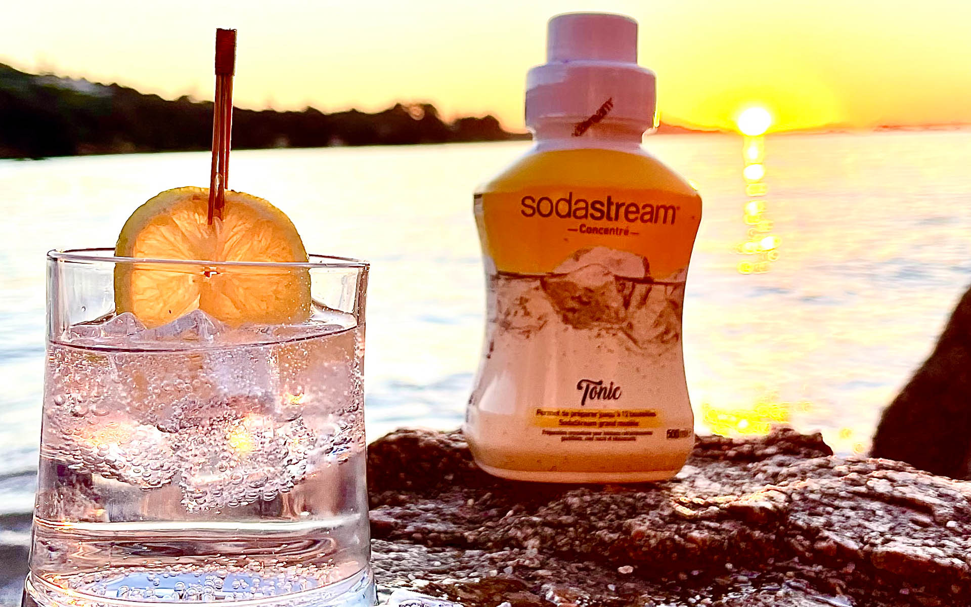 Tonic Sodastream pour cocktail rafraîchissant Bouteille de tonic Sodastream avec verre de cocktail au coucher du soleil.