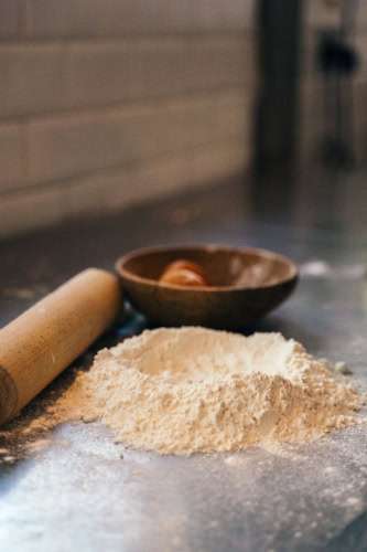 Tas de farine sur plan de travail en cuisine.